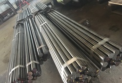 Bundles of metal bar stock laying on warehouse floor